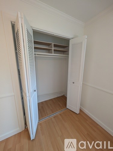 A white closet with a sliding door is open.