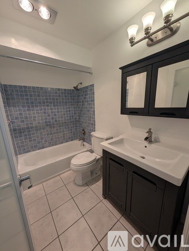 A bathroom with a toilet, sink, and shower.