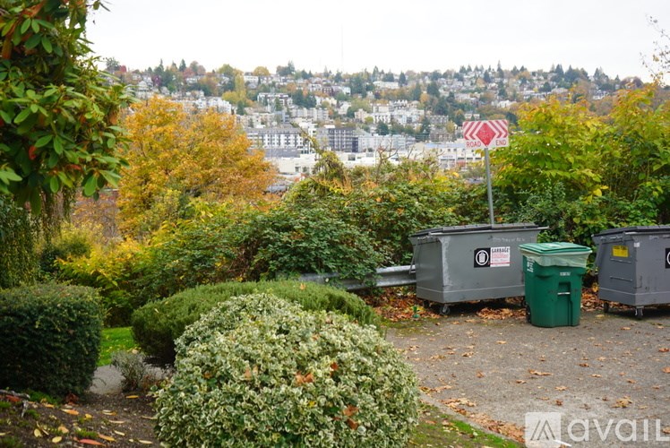 A red and white sign with a black border is in the middle of a garden.