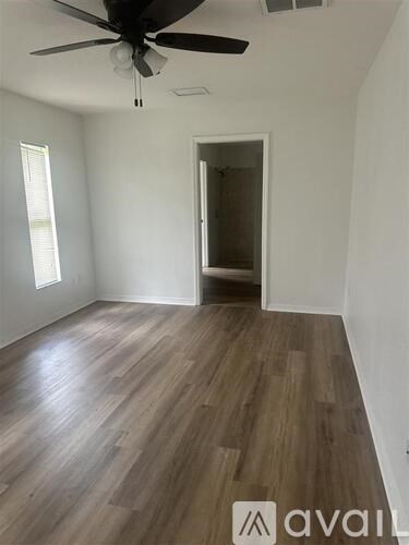A room with wooden flooring and a ceiling fan.