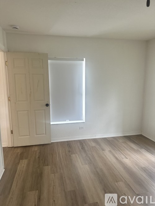 A room with a white door and a window with blinds.
