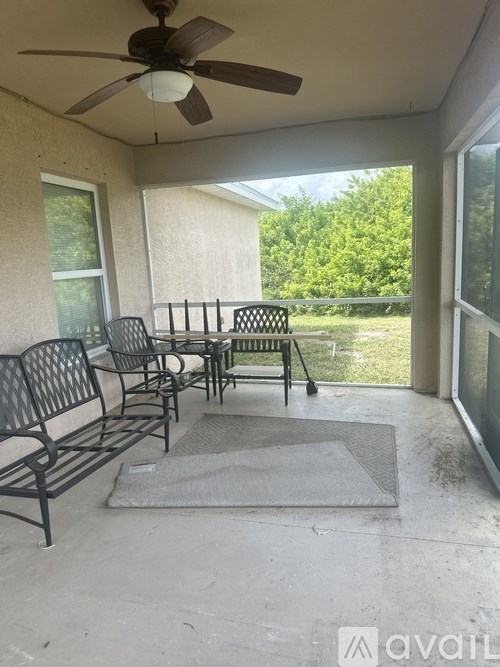 A patio with a table and chairs and a ceiling fan.