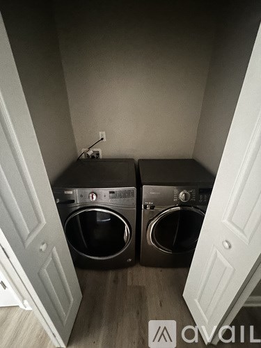 Two front load washing machines in a small laundry room.