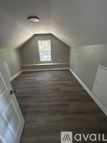 A room with wooden flooring and a window.