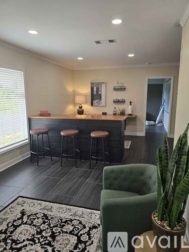 A bar area with a green chair and a potted plant.