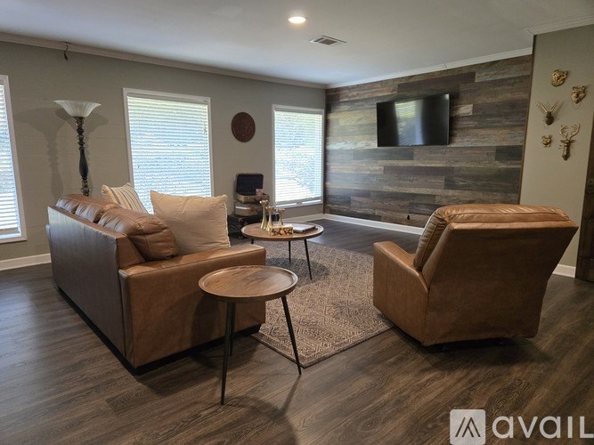 A living room with a brown couch, a chair, and a coffee table.