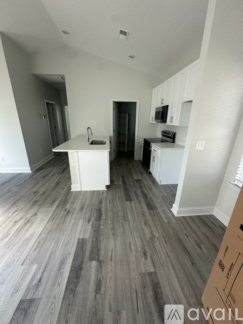 A kitchen with a white countertop and a microwave on top of it.