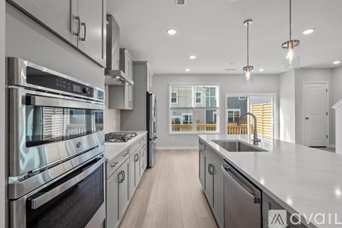 A modern kitchen with stainless steel appliances and a view of the backyard.