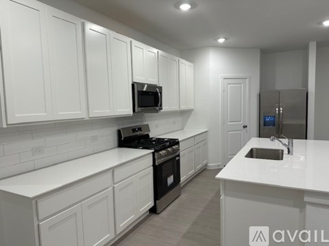 A modern kitchen with white cabinets and appliances.