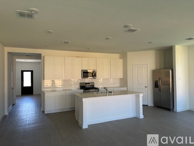 A modern kitchen with white cabinets and a central island.