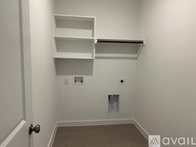 A white wall with a shelf and a door.