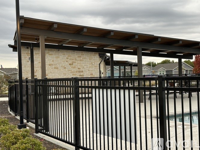 A black metal fence surrounds a pool area.