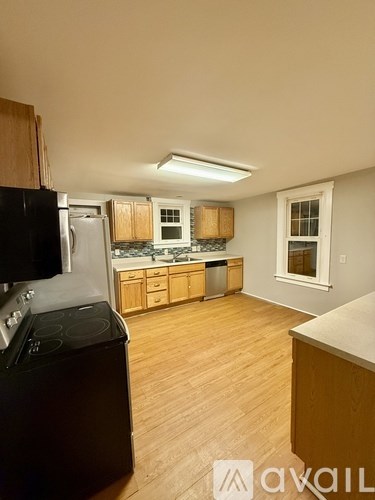 A kitchen with wooden cabinets and a black stove top oven.
