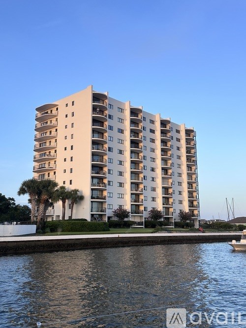 A tall apartment building with a body of water in front of it.