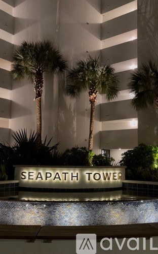 A sign that says Seapath Tower in front of some palm trees.