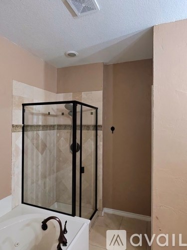 A bathroom with a white tub and a glass shower enclosure.