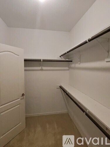 A white closet with a door and shelves.