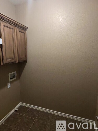 A room with brown cabinets and a brown tile floor.