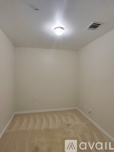 A room with a carpeted floor and a ceiling light.