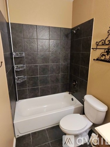 A bathroom with a white toilet and a white bathtub.