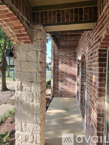 A brick column and wall with a lamp post.