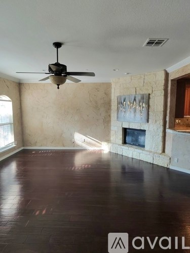 A room with a ceiling fan and a fireplace.