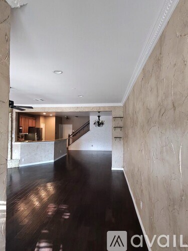 A hallway with a staircase and a chandelier.