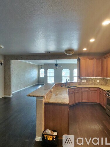 A kitchen with wooden cabinets and a marble countertop.