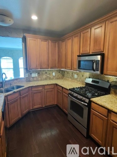 A kitchen with wooden cabinets and a granite countertop.