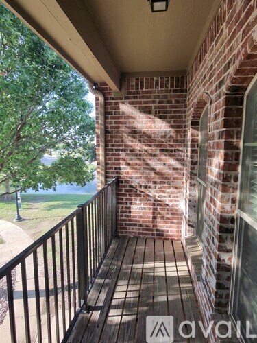 A balcony with a black railing and a brick wall.