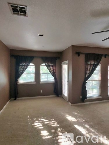 A room with a window and curtains.