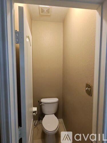 A small bathroom with a toilet and a door.