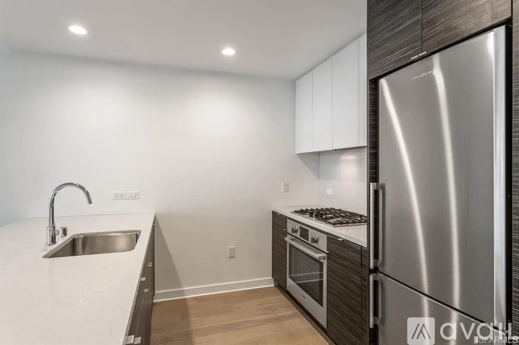 A modern kitchen with a stainless steel refrigerator and a sink with a faucet.
