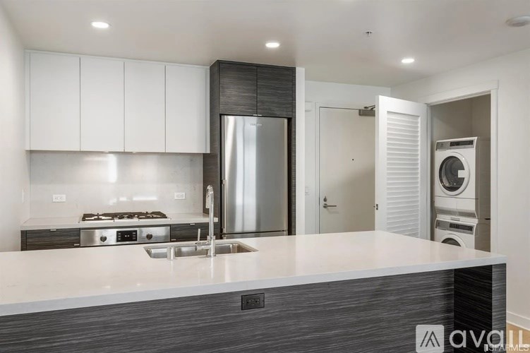A modern kitchen with a stainless steel refrigerator and a white countertop.
