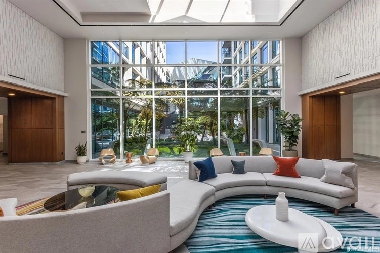 A modern living room with a curved sofa and a glass ceiling.