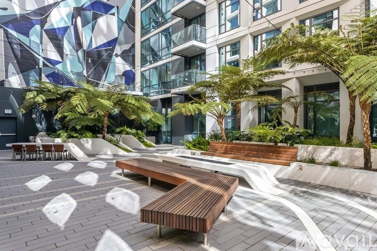 A modern courtyard with a bench and trees.