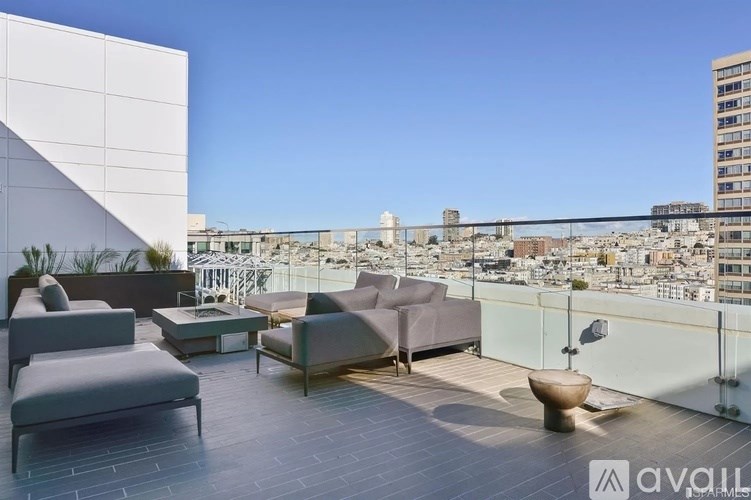 A patio with grey furniture overlooking a cityscape.