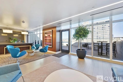 A modern living room with blue chairs and a large window.