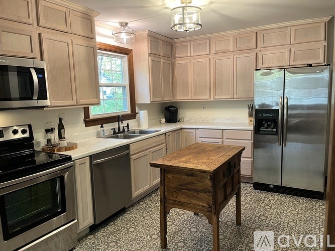 A kitchen with wooden cabinets and a black fridge.