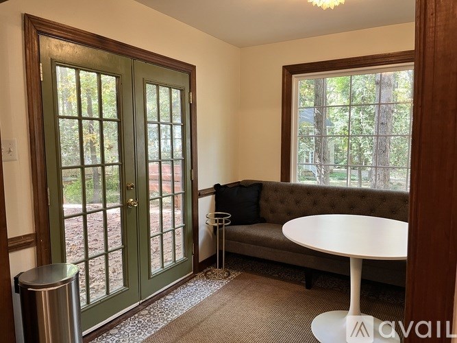 A room with a green door and a white table.