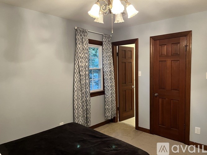 A bedroom with a large bed and a chandelier.