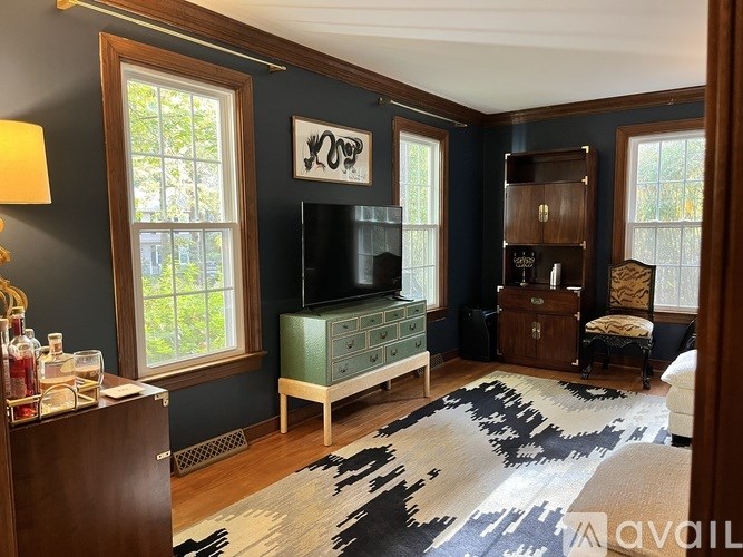 A living room with a black and white cowhide rug on the floor.