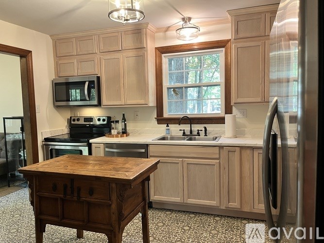 A kitchen with wooden cabinets and a wooden island.