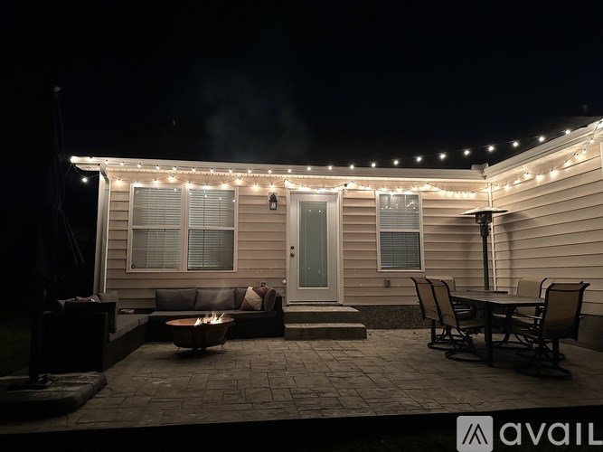 A house with a patio and lights strung up on the roof.