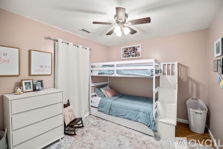 A bedroom with a bunk bed and a dresser.