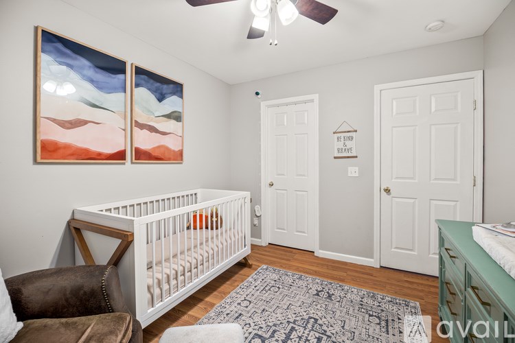 A baby room with a crib and a brown chair.