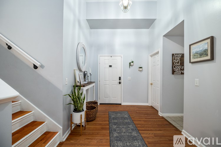 A hallway with a rug on the floor and a mirror on the wall.