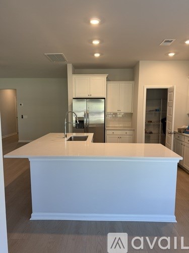 A modern kitchen with white cabinets and a large island.
