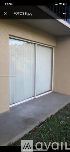 A balcony with a glass door and a concrete floor.