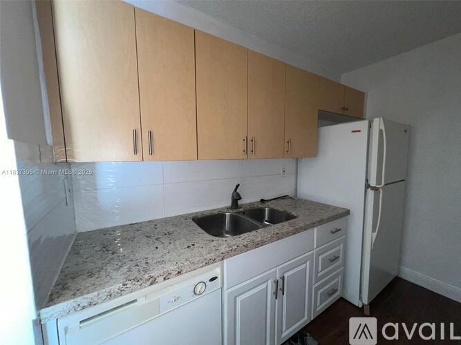 A kitchen with a granite countertop and white appliances.